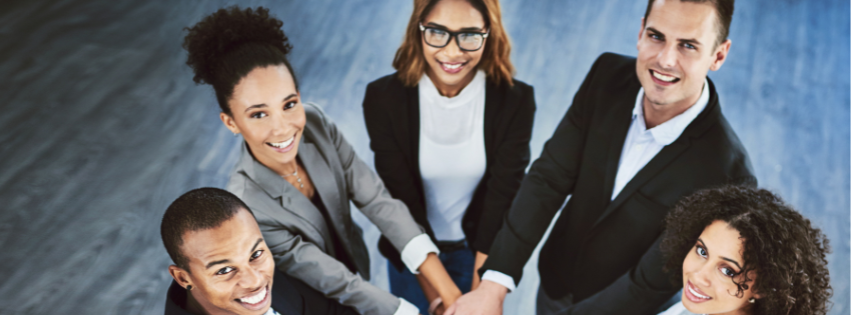 Five diverse business professionals in suits joining hands in collaboration from above, representing the unified leadership and teamwork of 22 Hands Up LLC Board of Directors
