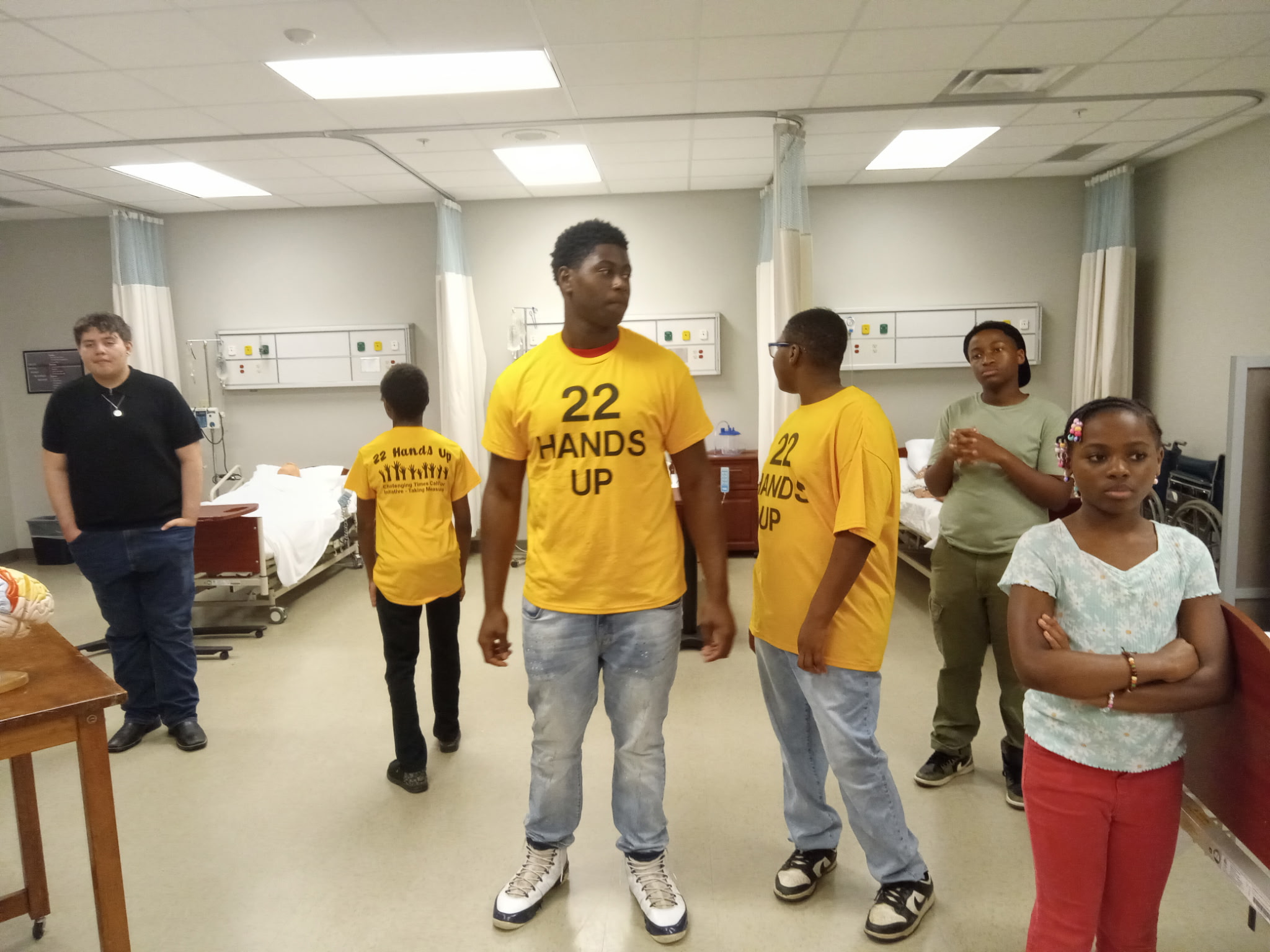 22 Hands Up students exploring the nursing simulation lab with hospital beds